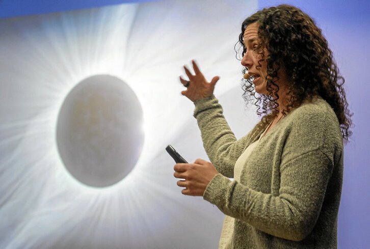 Virginia Garcia astronomoa, Donostiako hitzaldian, eguzki-eklipseetan bakarrik ikusten den eguzkiaren atmosferari buruz azalpenak ematen.