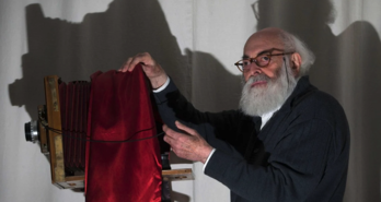 Adolfo Kaminsky argazki kameraren aurrean.