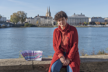 Marga Berra grafista, berak ekoizturiko diseinua daramaten liburuxkak ondoan dituela.