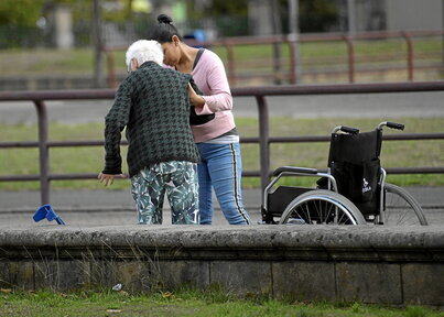 Zaintzaile bat adineko pertsona bati laguntzen.