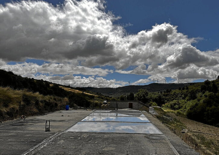Gatzagaren irudia, atzean haize errotak ikusten direla.