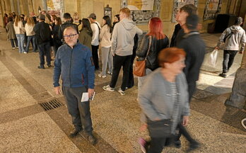 Marco Santopadre kazetari italiarra, Donostiako Parte Zaharrean. Atzean, turista ilara taberna bat irekitzeko zain.